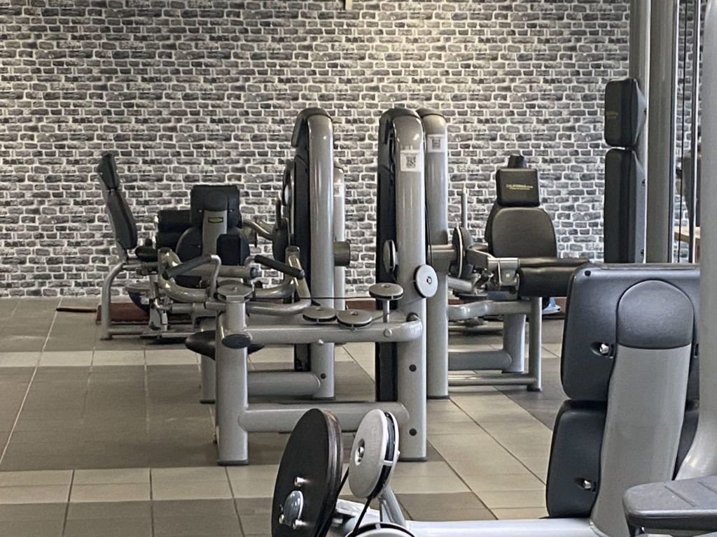 Faux mur en briques derrières des machines de musculation