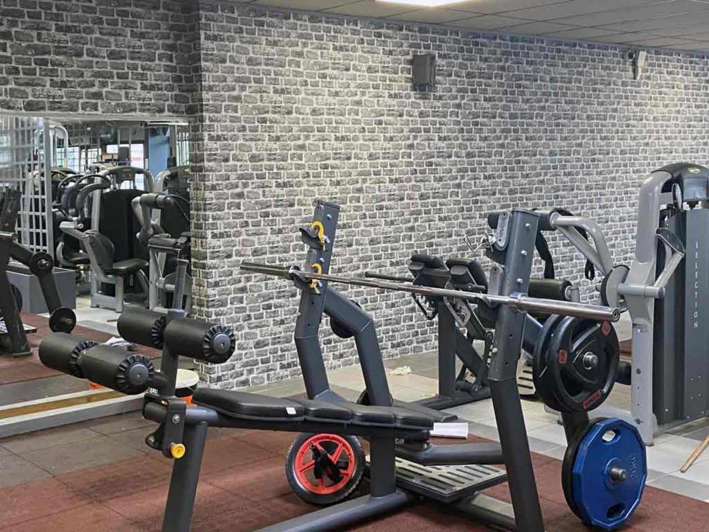 Faux mur en briques derrières des machines de musculation